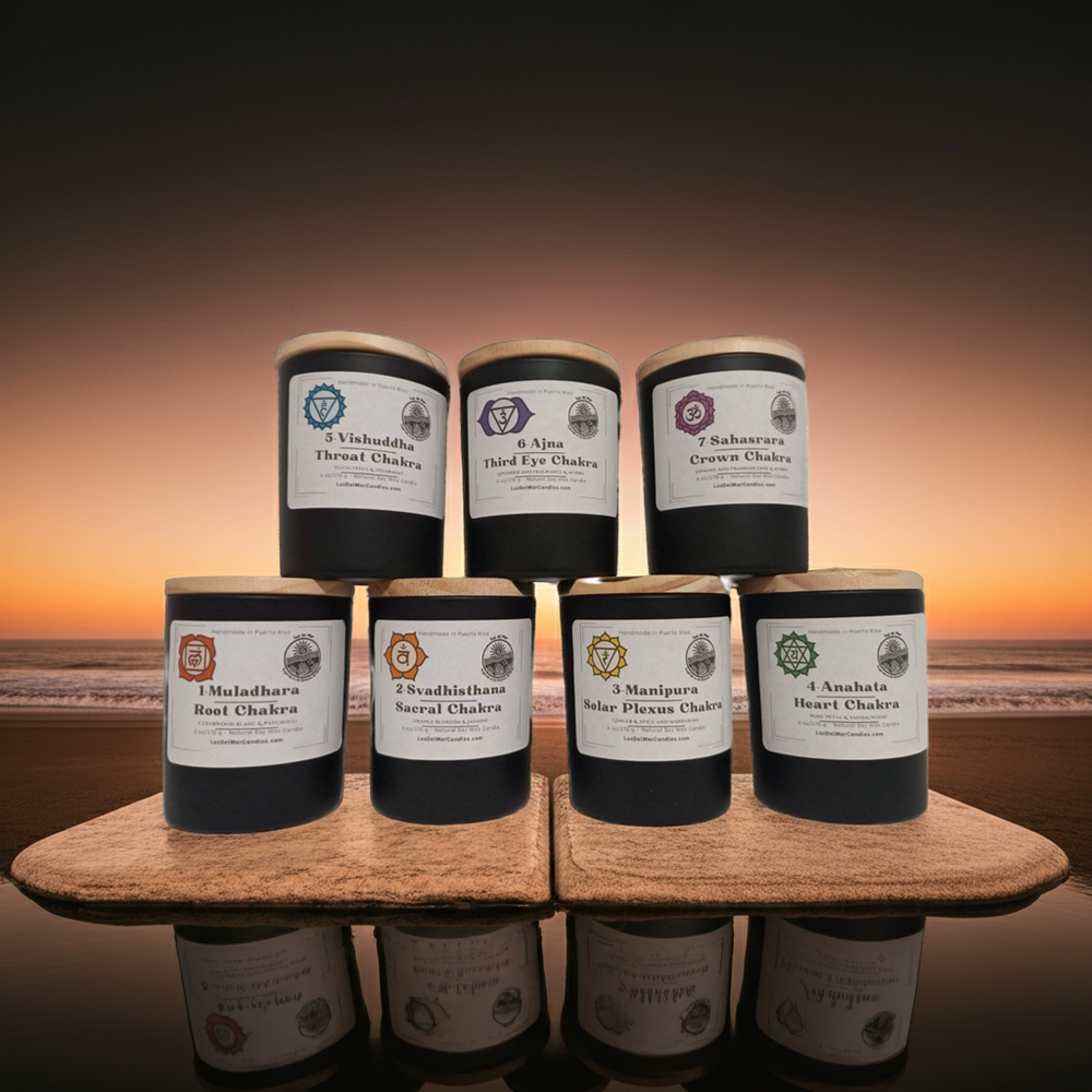 Set of candles with labels on a wooden stand against a sunset beach Chakra candle set by Luz del Mar Candles
background
