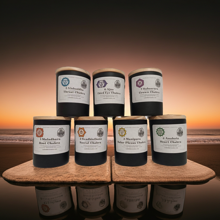 Set of candles with labels on a wooden stand against a sunset beach Chakra candle set by Luz del Mar Candles
background
