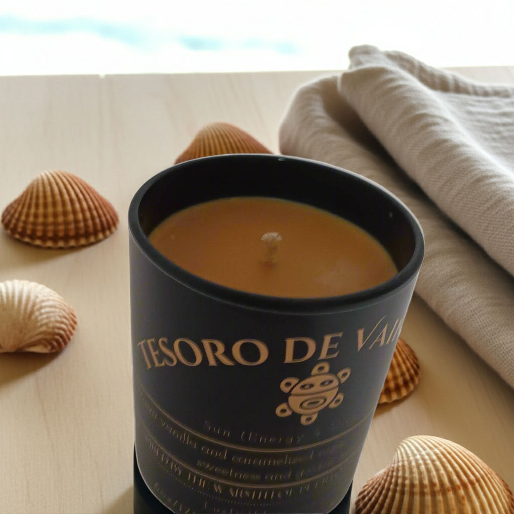 close up of Tesoro-de-Vainilla Candle  by Luz del Mar Candles with seashells on a light surface.