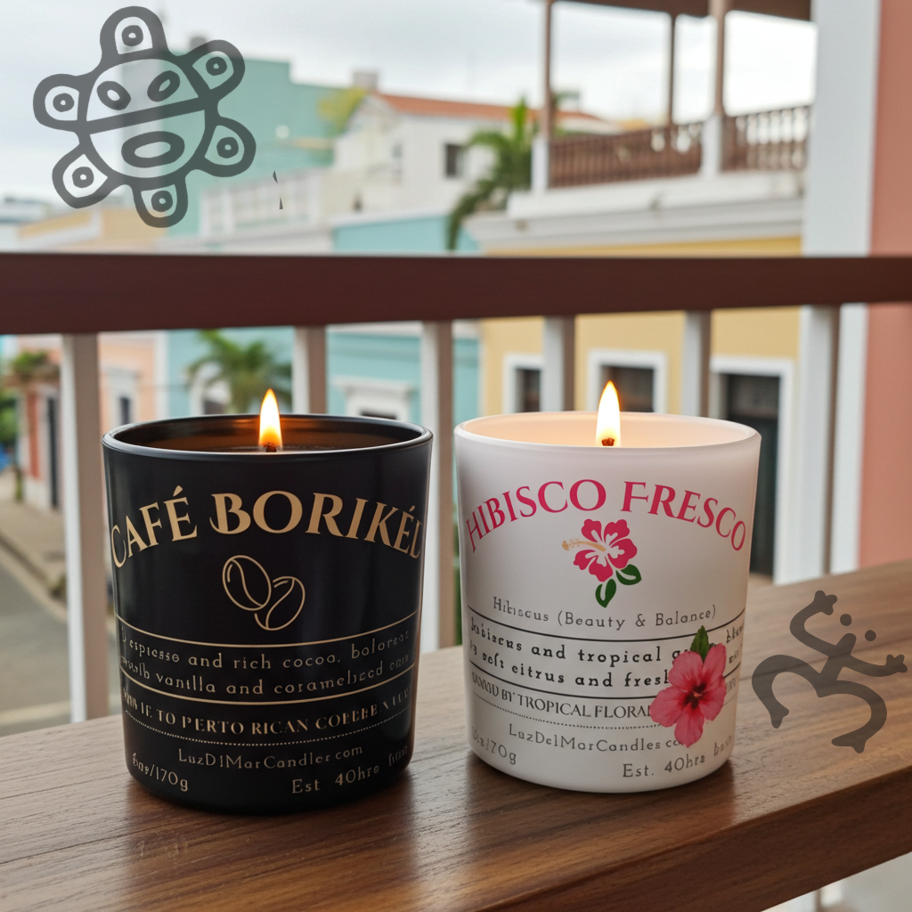 Two lit candles by Luz del Mar Candles, one labeled 'Café Boriké' and the other 'Fabisco Fresco', on a wooden surface with a blurred outdoor background.