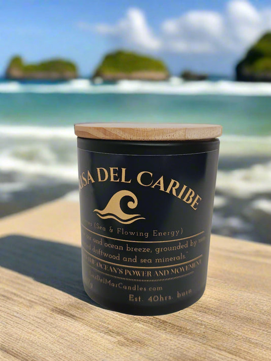 brisa-del-caribe-ocean-breeze-candle set on the corner of a wooden table at the beach