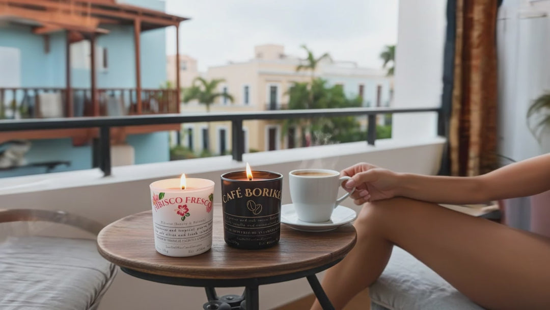 Video of Two lit candles by Luz del Mar Candles, one labeled 'Café Boriké' and the other 'Fabisco Fresco', On a balcony table set in Old San Juan, Puerto Rico As a woman relaxes and sips a cup of coffee.