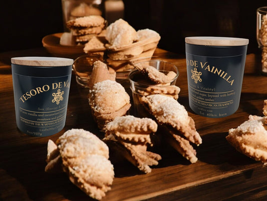 tesoro-de-vainilla-warm-vanilla-candles sitting on a table covered with sweet pastries.